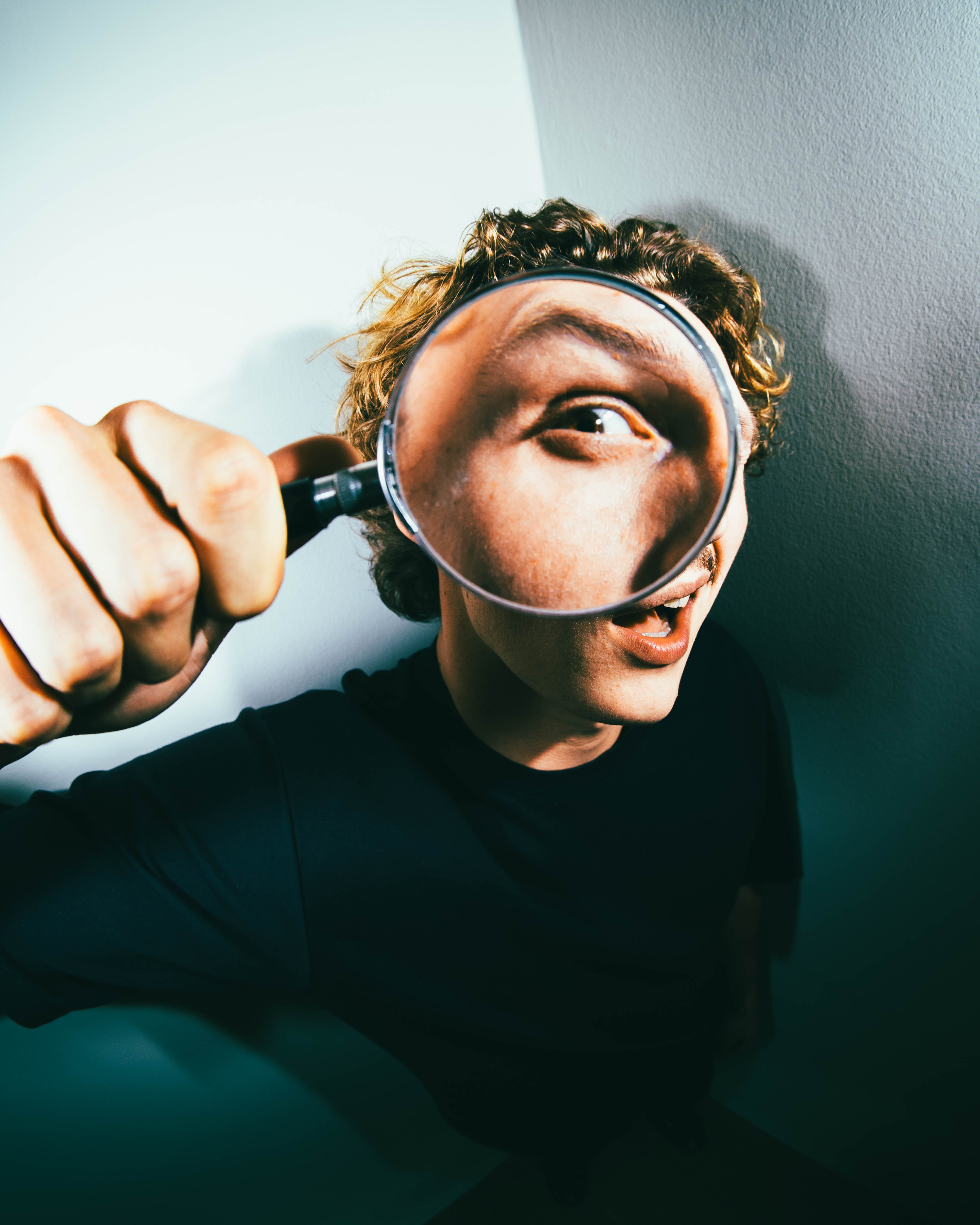 Young man looking through a looking glass.