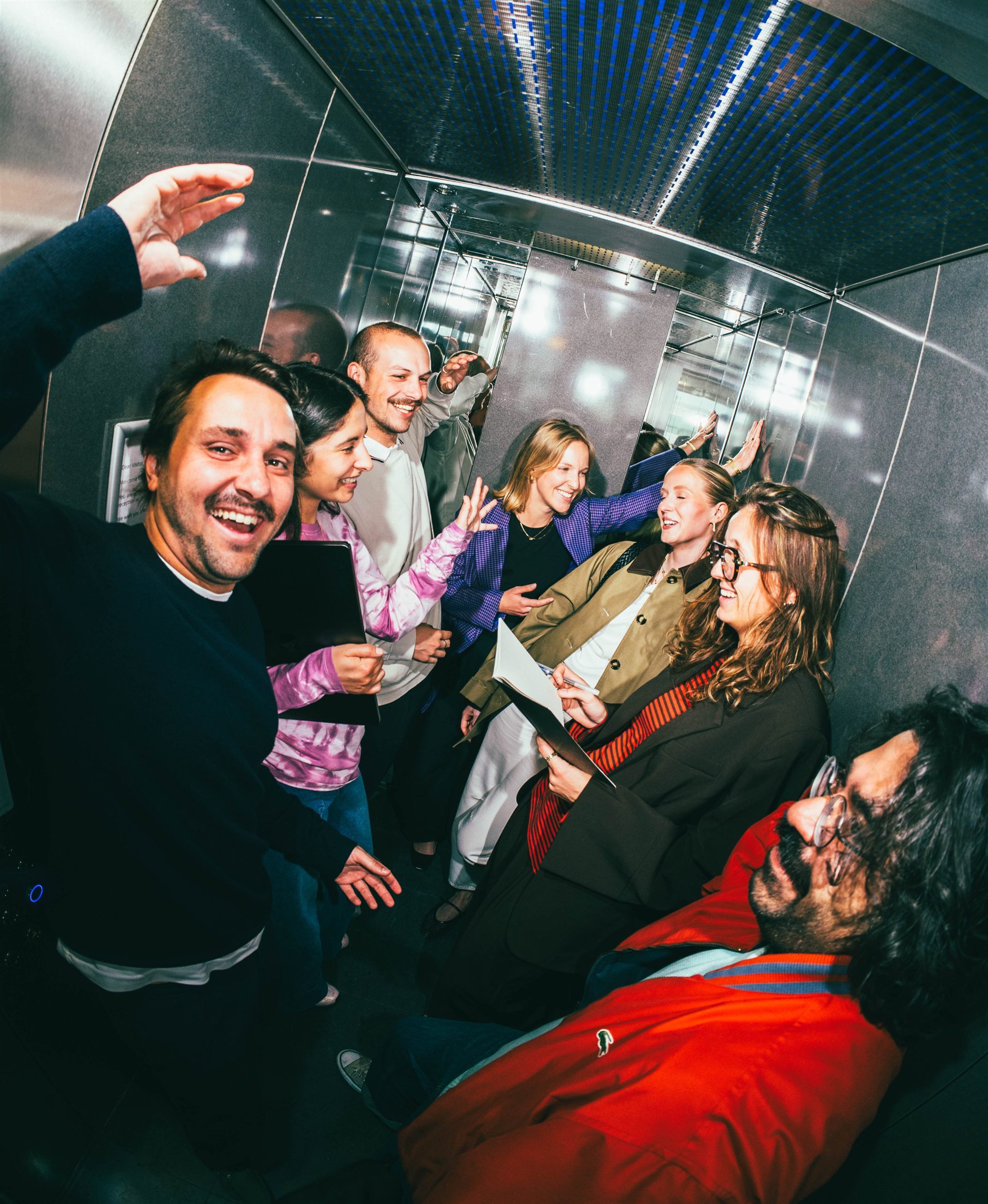 Group of young people laughing in an elevator.