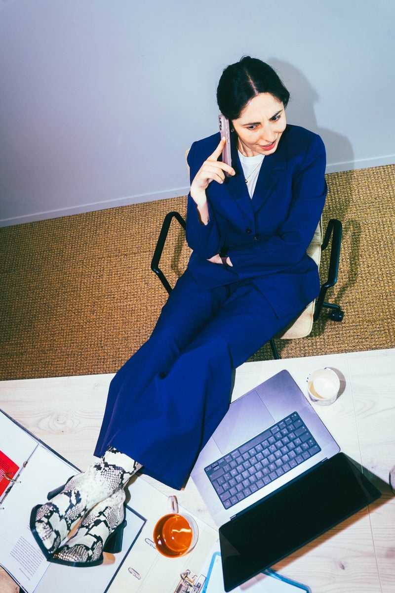 Young woman calling with her shoes on her desk.